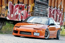Оранжевый Nissan Silvia/SX около разрисованного вагона
